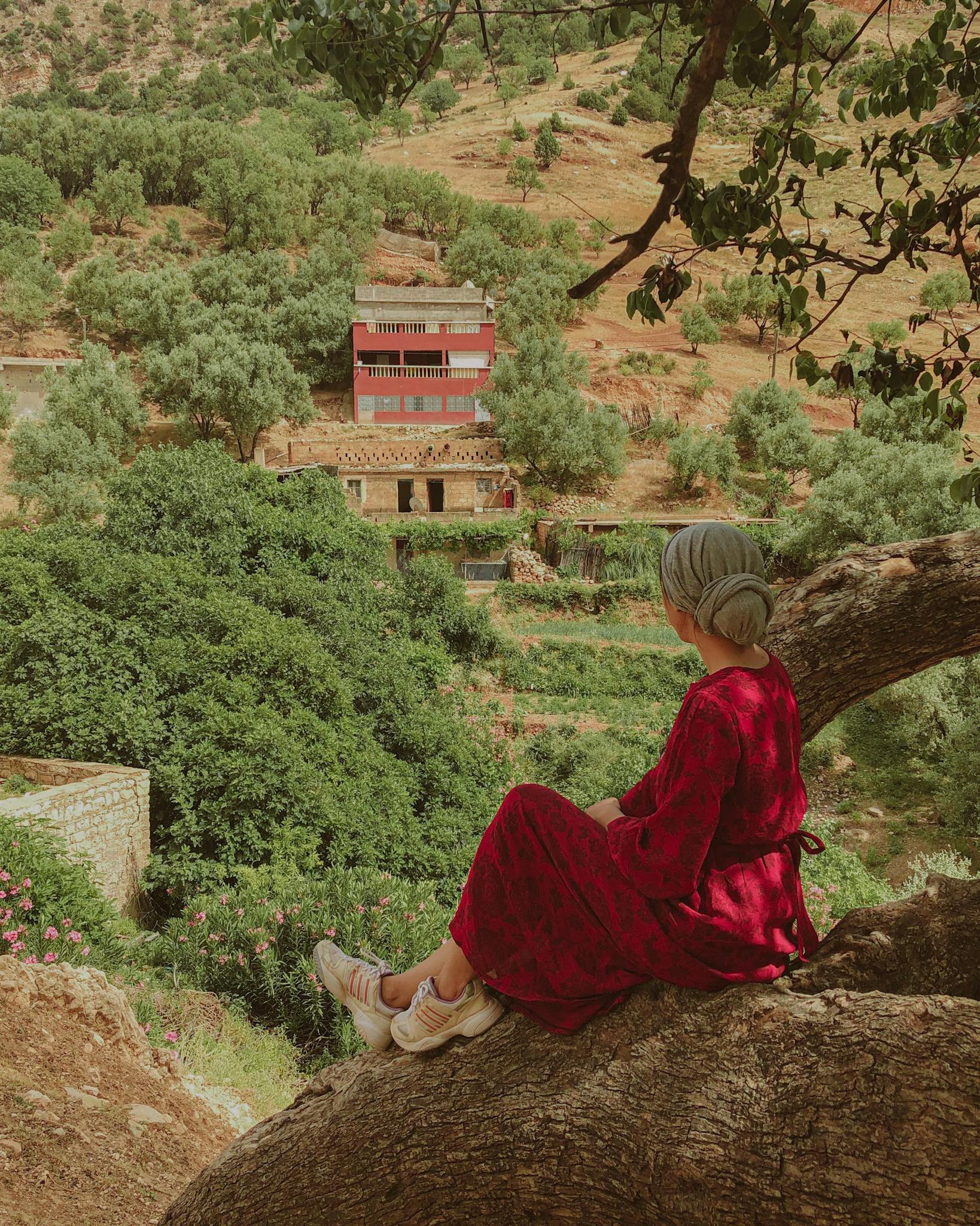 Woman in red dress enjoying scenic views in Béni Mellal-Khenifra, Morocco.